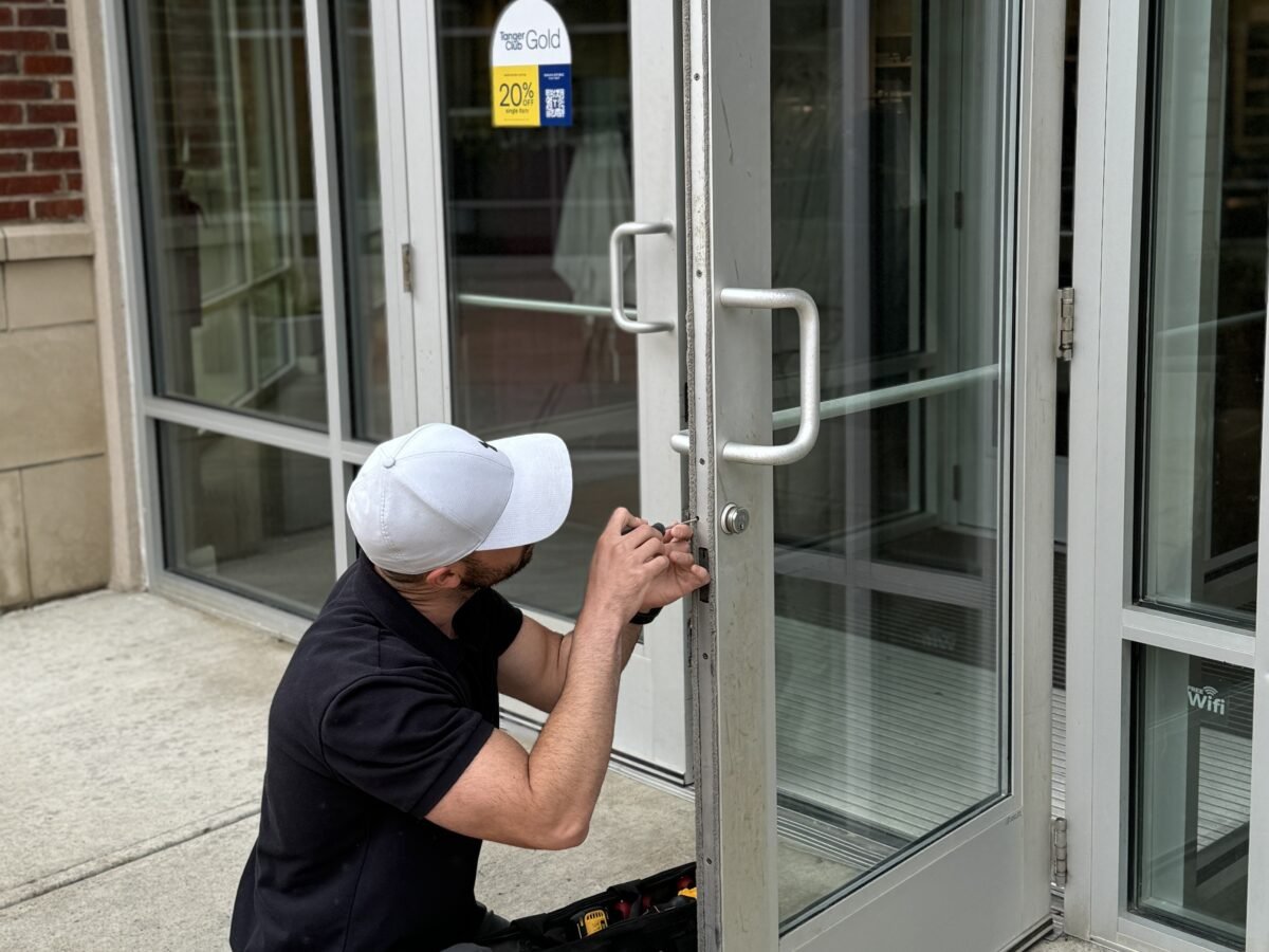 Locksmith servicing a commercial storefront door lock